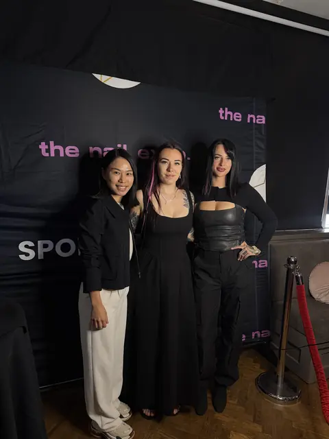 Guests posing at The Nail Expo photo backdrop